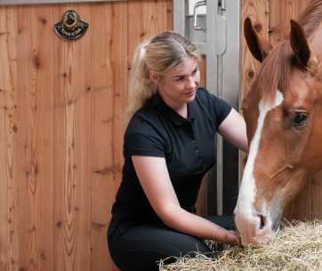 Frau kümmert sich um ihr Pferd