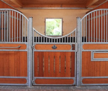 Box pour chevaux en acier galvanisé avec panneaux en bois et design incurvé pour une meilleure circulation d’air. Conseils d’entretien du zinc pour une écurie durable et résistante