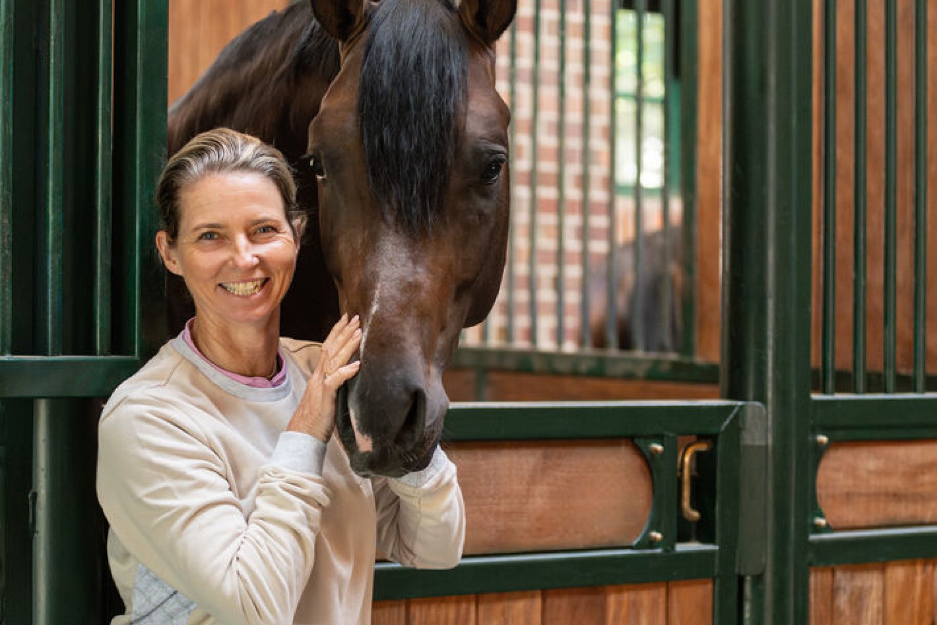 Eva Moeller steht vor Pferdebox mit einem Pferd