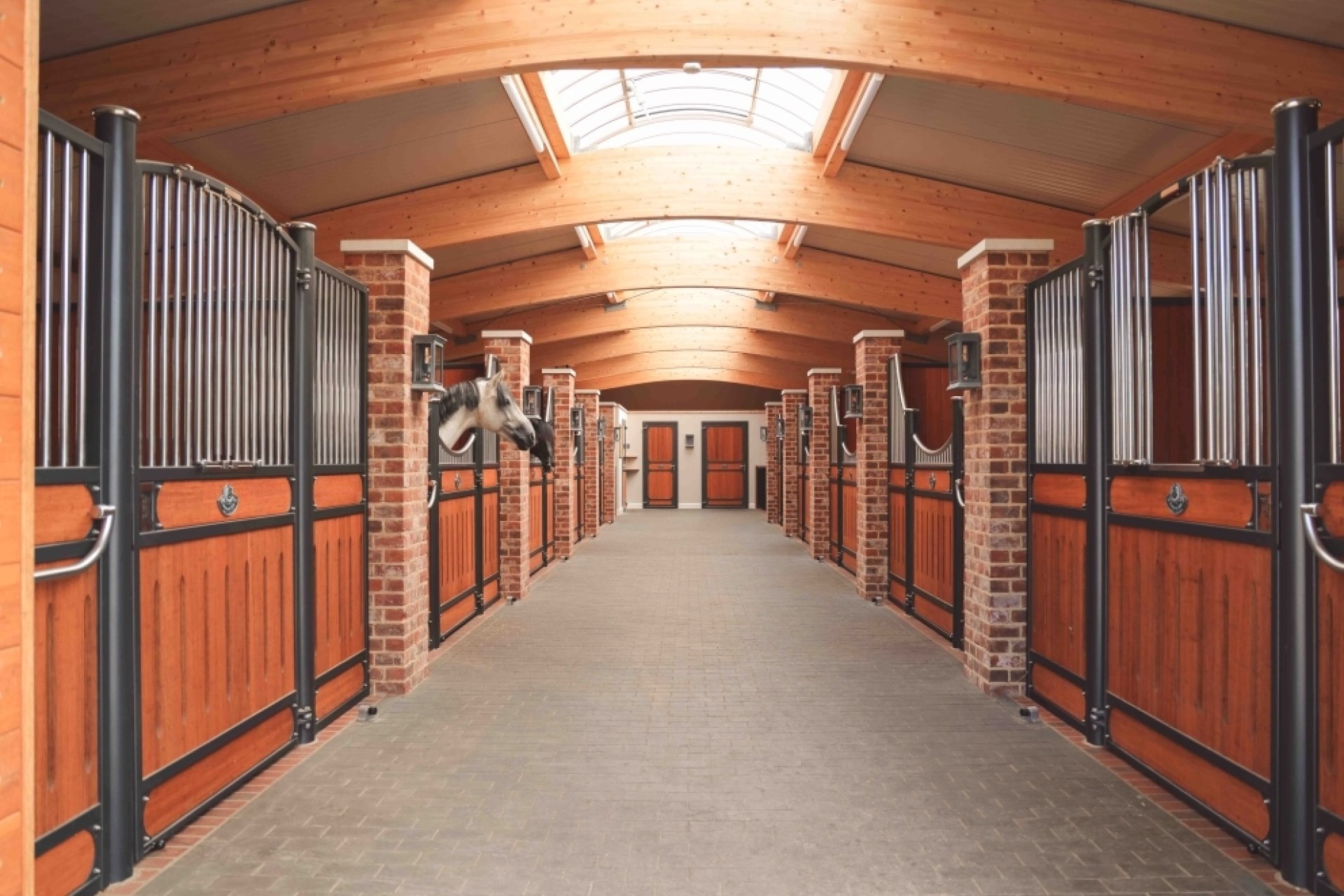 Stallgasse mit Pferdeboxen Hannover und Bremen mit Mauerwerkständer, Lichtfirst mit Leimholzbinder